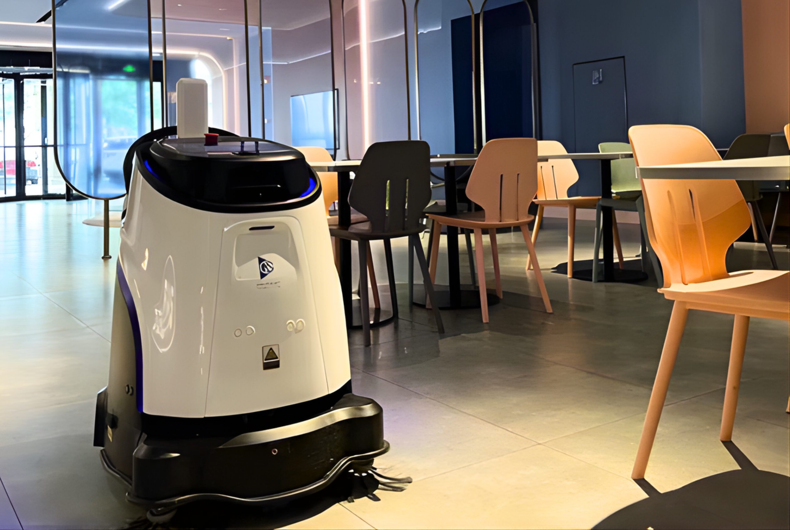 A Gausium Vacuum 40 autonomously  cleaning a cafeteria space.